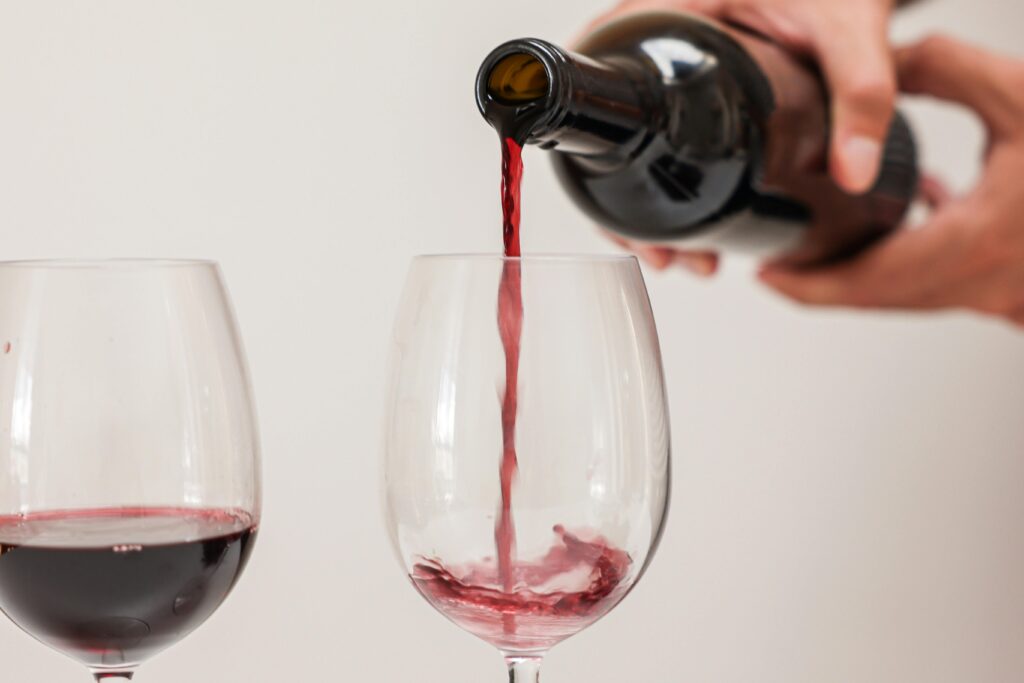 person pouring wine into a glass