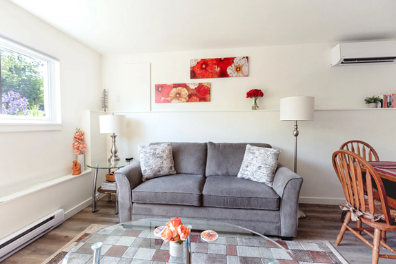 A couch with two pillows inside Giselle's Garden Suite in Nanaimo